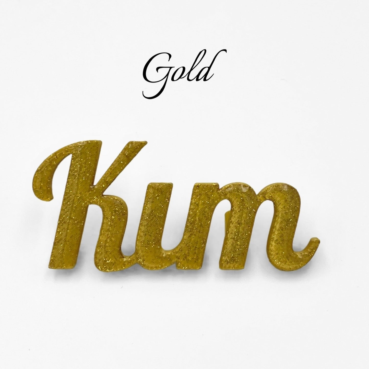 A close-up studio shot of a gold glitter 3D printed personalised name plate spelling "Kim" on a plain white background. The word "Gold" is written in a cursive font above the name.